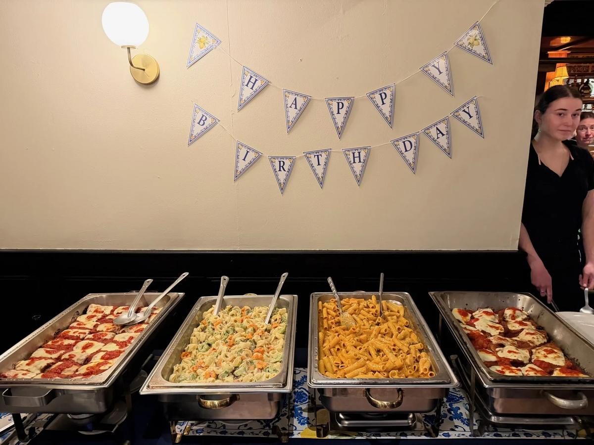 Party buffet trays set out under a Happy Birthday banner