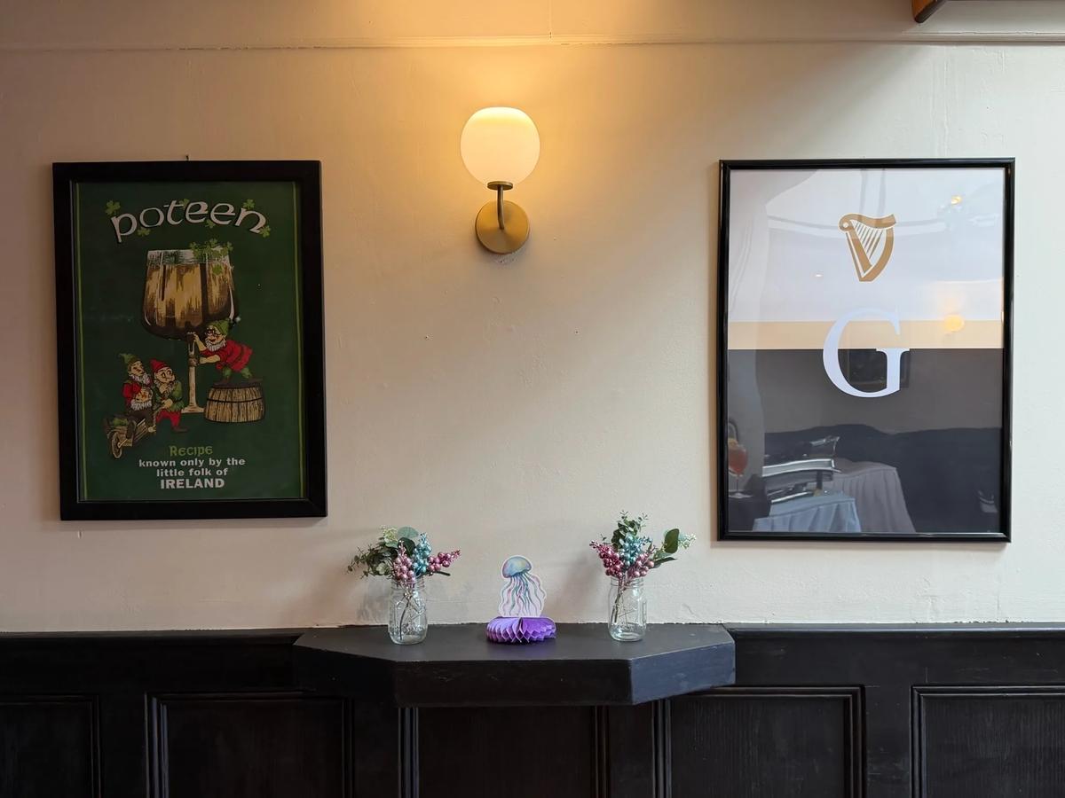 Corner of the event room with an Irish poster and a framed harp