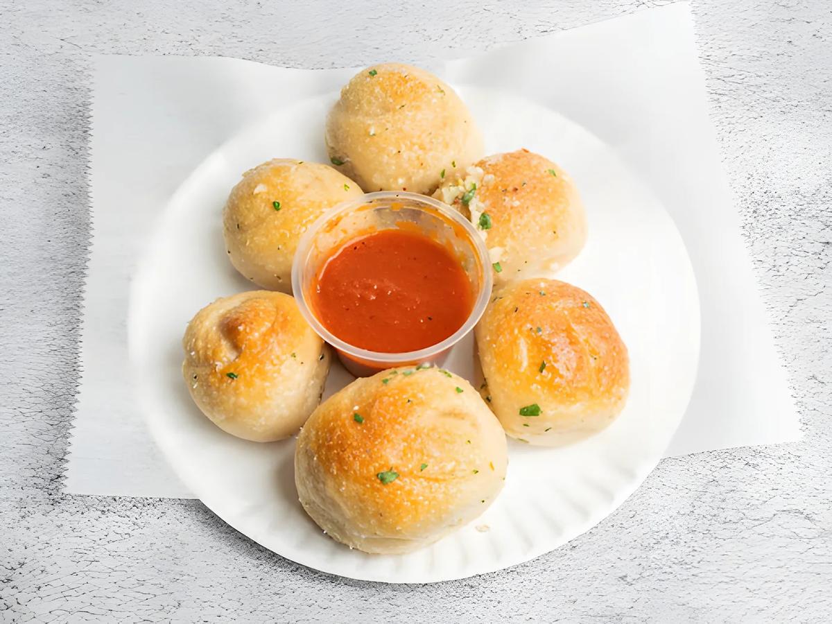 Garlic knots with a cup of sauce
