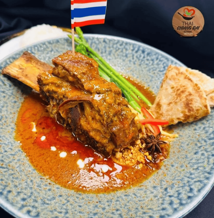 Braised rib in a rich curry sauce with roti and asparagus