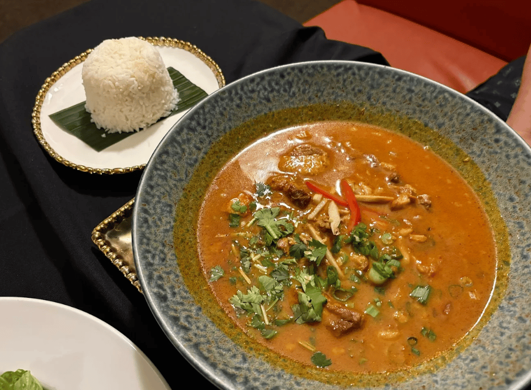 A bowl of curry with a dome of jasmine rice