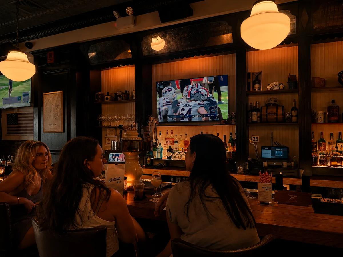 Friends at the bar with the game on