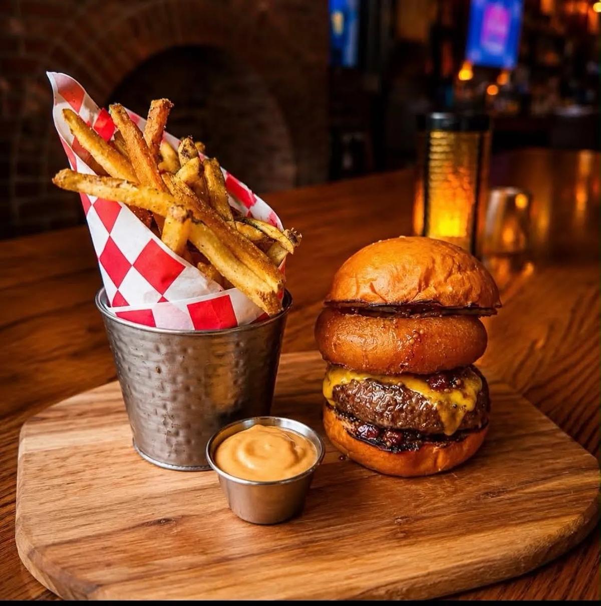 A burger and fries on a wooden board