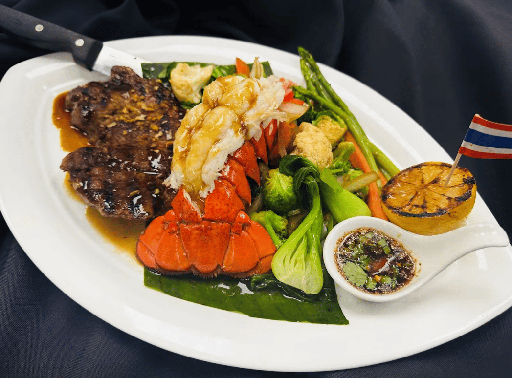 Steak and lobster tail with vegetables and dipping sauce