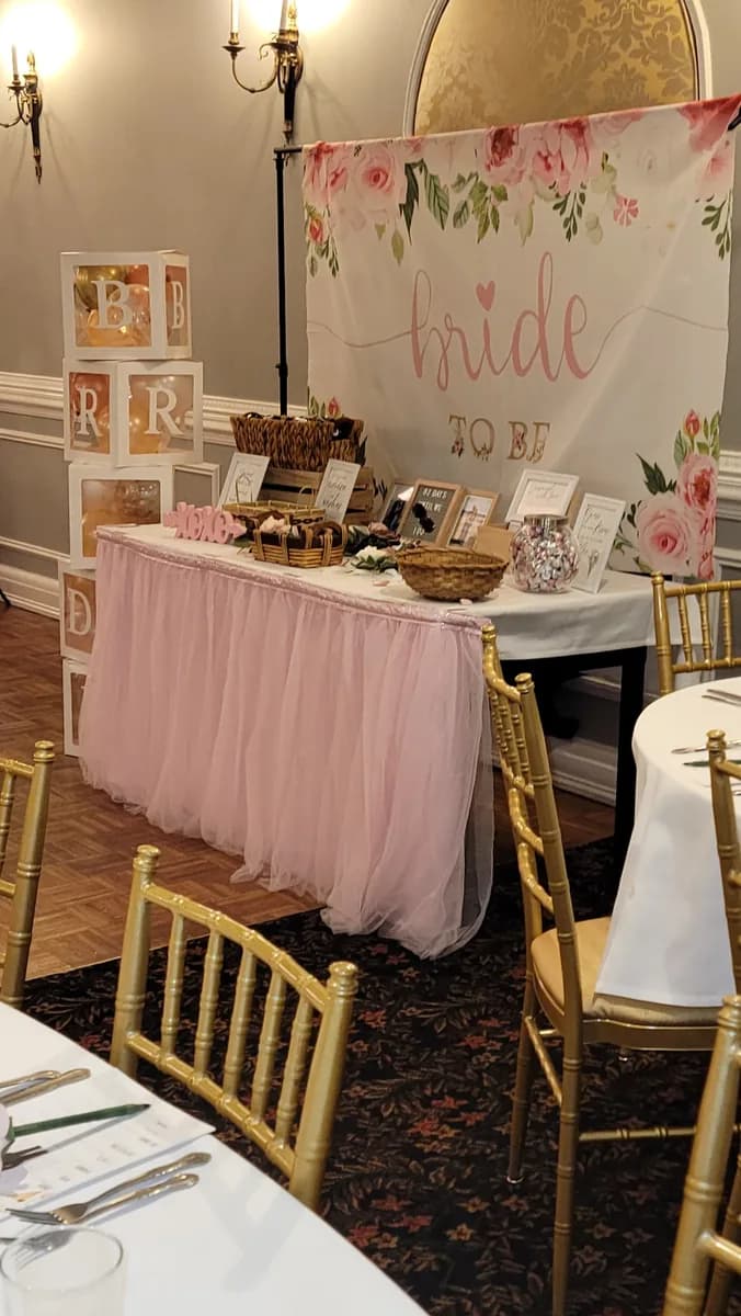 A bridal shower welcome table with a pink skirt