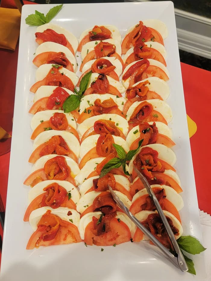 Caprese salad with tomato, mozzarella and basil on a long platter