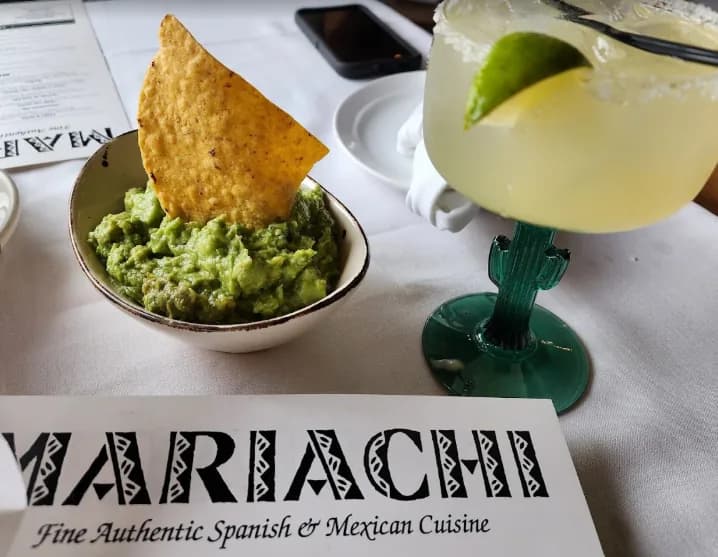 Guacamole with a tortilla chip and a margarita on a Mariachi Restaurant placemat