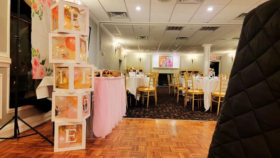 A bridal shower set up with pink decorations and a dessert table