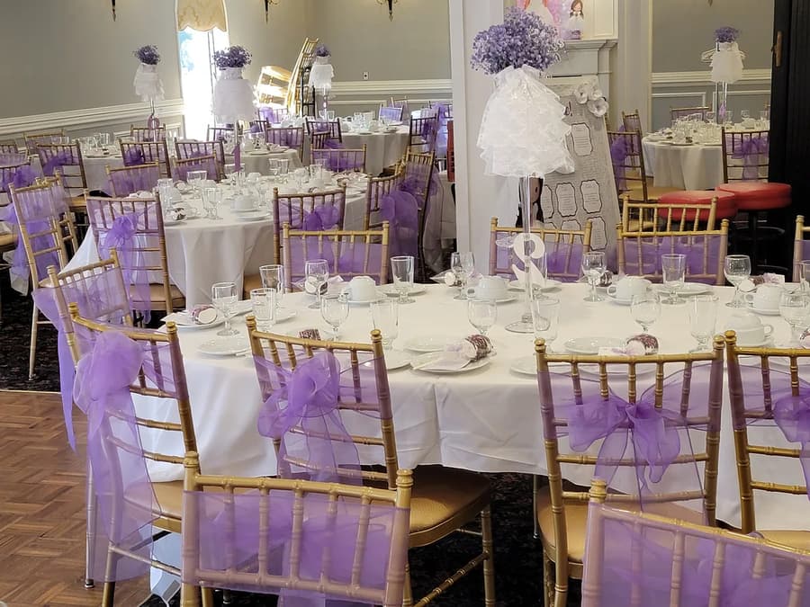 Communion tables with lilac bows and gold chairs