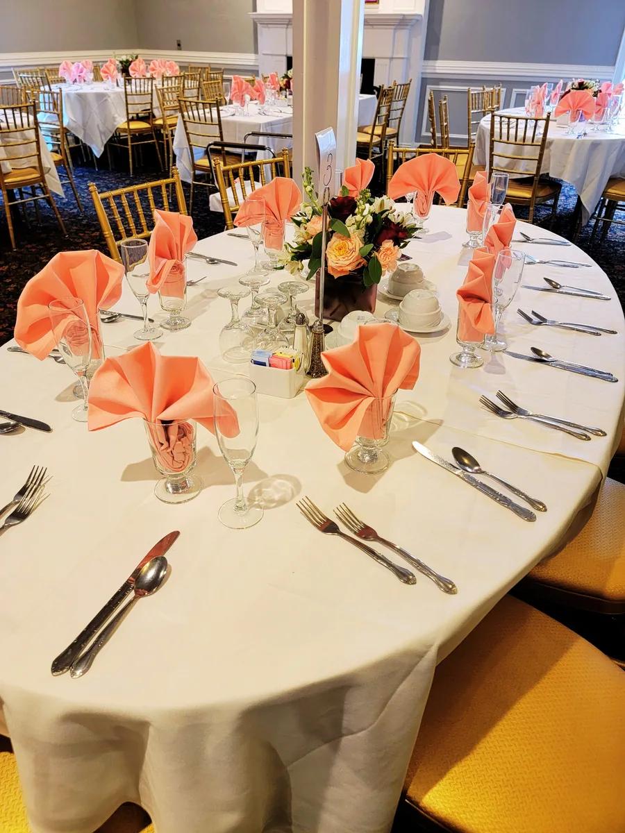 Engagement party tables with peach napkins and flowers